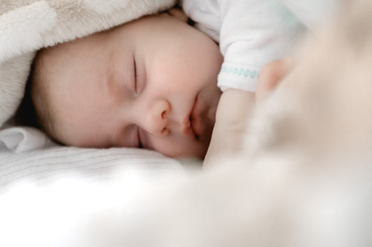 Baby resting in a coconut milk colored cocoon lounger